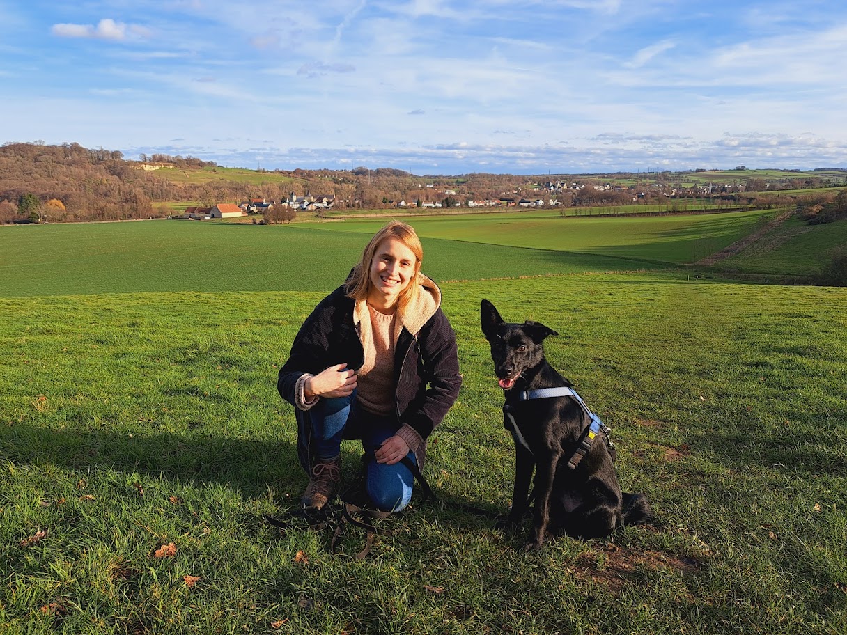 Dierenarts Céline met haar hond Flo in een groot groen veld